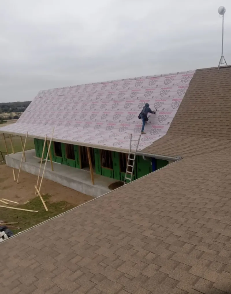 Worker preparing underlayment for a metal roof installation in Harrisonburg